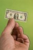 2642070-a-hand-holding-a-miniature-united-states-one-dollar-bill-depicting-the-shrinking-united-.jpg